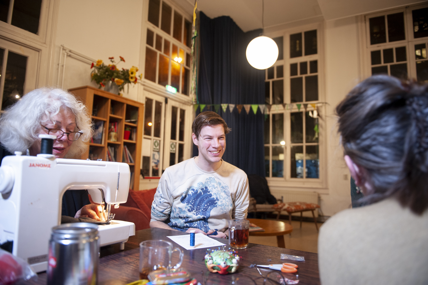 De textielafdeling van Repair Café Jeltje, met Joke Lochtenbergh aan de naaimachine en een klant die zelf komt repareren. Reparatie van confectie en zelf kleding maken.