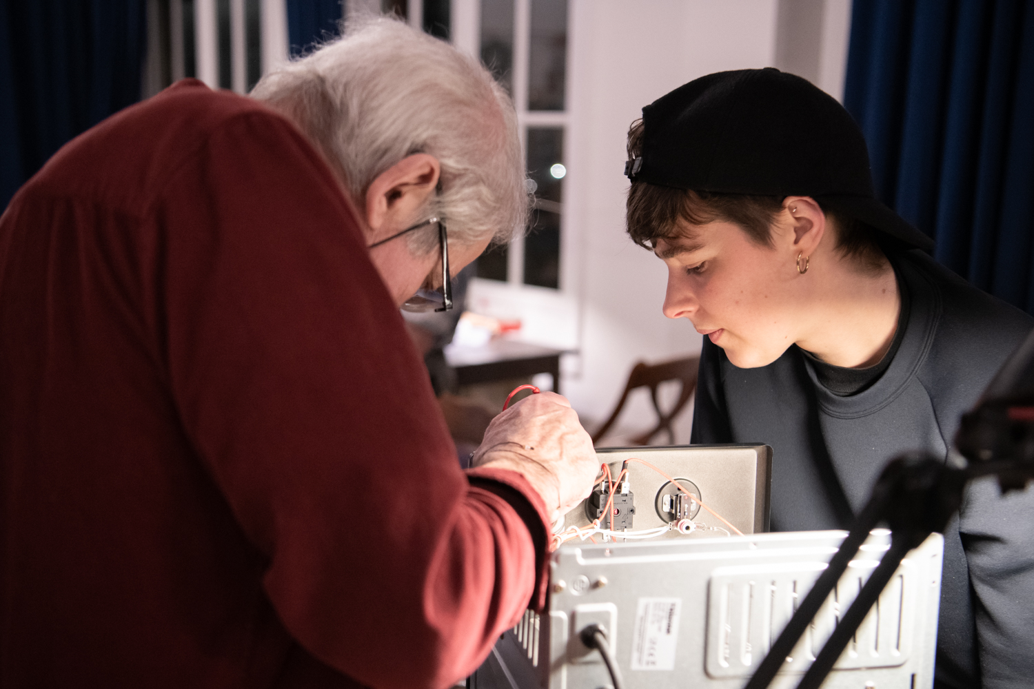 repaircafejeltje-amsterdam-west-foto-lucy-lambriex-ziebinnenzijde-1636 Reparateur en bezoeker kijken samen in kapotte oven