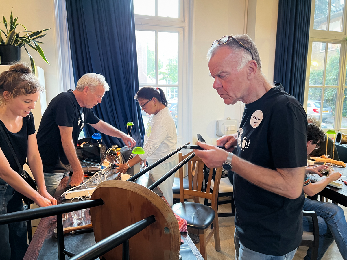 Stoel-reparatie tijdens het feest ter ere van vijf jaar Repair Café Jeltje in Amsterdam Oud-West